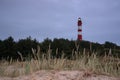 Leuchtturm Amrum lighthouse on a hill covered in the grass under a cloudy sky in Nebel, Germany Royalty Free Stock Photo