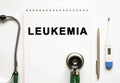 LEUKEMIA text written in a notebook lying on a desk and a stethoscope