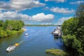 Beautiful idyllic lake, sport boats harbour, green forest, sand beach, blue summer sky