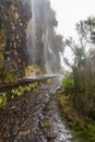 Levada da Serra hiking trail with falling waterfalls above Encumeada mountain pass in Madeira