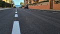 Level asphalted road with a dividing white stripes. The texture of the tarmac, top view.