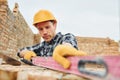 With level measuring tool. Construction worker in uniform and safety equipment have job on building Royalty Free Stock Photo