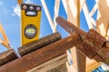 Level Tool Positioned on Wooden Beams at a Construction Site Under a Clear Blue Sky Royalty Free Stock Photo