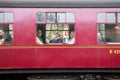 Old heritage train railway cariage with family seated inside viewed through window from outside