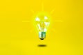 Levitating burning bulb on a yellow background Royalty Free Stock Photo