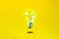 Levitating burning bulb on a yellow background Royalty Free Stock Photo