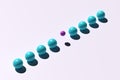 Levitating little purple ball stands out from the crowd of blue balls on pink background Royalty Free Stock Photo