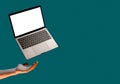 Levitating mockup template laptop with keyboard, blank screen with copy space and male hand on green background for ad