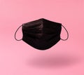 Levitating real black surgical mask with soft shadow on a blue background