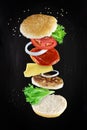 Levitating sandwich cheeseburger ingredients on dark background. Burger components floating in the air