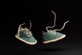 Flying baby shoes with laces on black background. Childhood concept with levitation effect