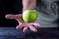 Levitation fresh green apple on a wooden table.