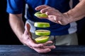 Levitation fresh slices of a green apple, over a wooden table.