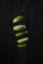 Levitation of a green apple cut into slices on dark wooden background Royalty Free Stock Photo