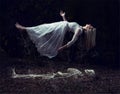 Levitation image of a woman rising from a skeleton on dead leaves