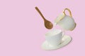 Levitation white coffee cup and saucer with milk pouring from a milk jug with a floating wooden spoon Royalty Free Stock Photo