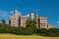 Lews Castle on blue sky in Stornoway, United Kingdom. Castle with green trees on natural landscape. Victorian style Royalty Free Stock Photo