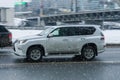 Lexus GX 460 car drives in winter snowfall in city. Risk on snow or ice skidding concept