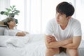 Lgbt Asian gay couple quarreling and irritated in bedroom. Stressed young man sitting at end of bed with arms crossed Royalty Free Stock Photo