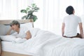 Lgbt Asian gay couple quarreling and irritated in bedroom. Young man made sullen face and lay in bed Royalty Free Stock Photo