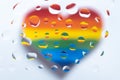 LGBT: a colorful heart in blurry focus under water drops on a white background Royalty Free Stock Photo