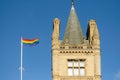 LGBT flag seen flying next to a historical, UK University campus gothic tower.
