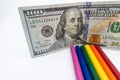 LGBT and Gay Pride rainbow colored pencils with a $100 bill against a white background. Equality and Diversity concept - image Royalty Free Stock Photo