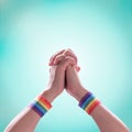 LGBT pride month with rainbow flag ribbon wristbands on LGBTQ people holding hands isolated with clipping path