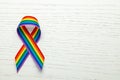 LGBT rainbow ribbon pride symbol. Stop homophobia. White wood background. Copy space for text.