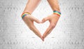 Male hands with gay pride wristbands showing heart Royalty Free Stock Photo