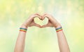 Male hands with gay pride wristbands showing heart Royalty Free Stock Photo