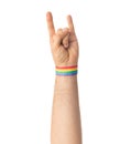 Hand with gay pride rainbow wristband shows rock
