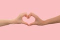 LGBT. Two females hands shows the heart sign with their fingers. Pink background. Copy space. The concept of the LGBT movement and Royalty Free Stock Photo