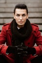 LGBTQ community lifestyle concept. Young homosexual man sits on a stairs. Handsome fashionable gay male model poses in Royalty Free Stock Photo