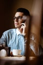 LGBTQ community lifestyle concept. Young homosexual man sits at the table in old-fashioned city cafe. Handsome gay male