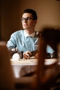 LGBTQ community lifestyle concept. Young homosexual man sits at the table in old-fashioned city cafe. Handsome smiling