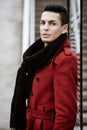 LGBTQ community lifestyle concept. Young homosexual man stands near glass. Handsome fashionable gay male model poses in