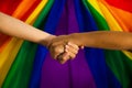 LGBTQ flag and hand. Pride flag symbol of Lesbian Gay Bisexsual Transgender. people holding hand on pride rainbow flag