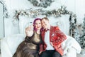 LGBTQ lesbian homosexual couple celebrating Christmas or New Year. Gay young lady female woman with butch partner taking selfie or