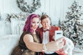 LGBTQ lesbian homosexual couple celebrating Christmas or New Year. Gay young lady female woman with butch partner taking selfie or