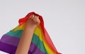 LGBTQ people raise their hands with a rainbow flag