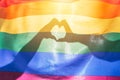 LGBTQ rainbow colors flag, a symbol for the homosexual community, two hands making a heart shape shining by sunlight. Gay flag for Royalty Free Stock Photo