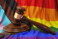 LGBTQ rights concept, wooden gavel with rainbow flag, 3D rendering