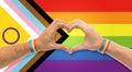 male hands with gay pride wristbands showing heart Royalty Free Stock Photo