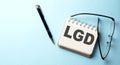 LGD - Loss Given Default text written on a notepad on the blue background Royalty Free Stock Photo