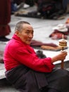 Tibetan female monk spinning prayer wheel