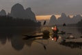 Li River - Xingping, China. January 2016 - An old fisherman gets ready to go out fishing with his cormorants.