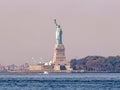 Liberty island, New York City - Statue of Liberty on Hudson river during cruise sunset at dusk