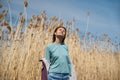 Liberty, peace of mind concept. Beautiful young woman walking in golden wheat field with cloudy blue sky background, free space Royalty Free Stock Photo