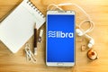 Libra coin cryptocurrency and block chain symbol and notepad with pencil and smart phone on wooden table , a New digital